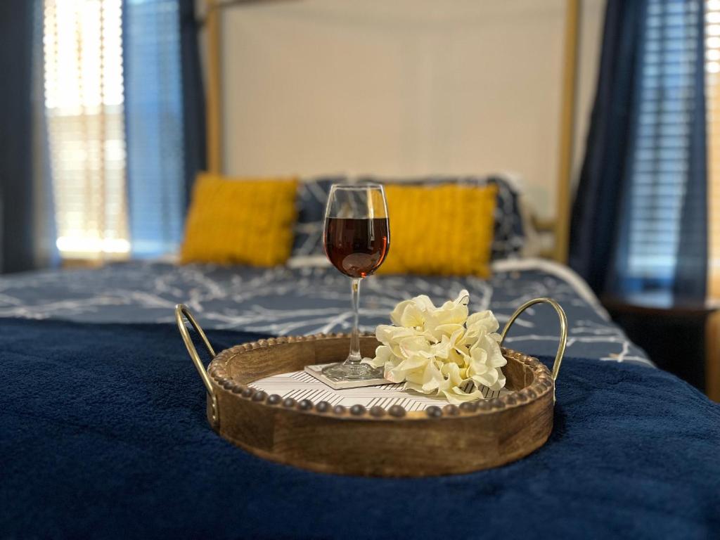 a glass of wine and a basket of flowers on a bed at Charming Cozy Casita in Santa Teresa