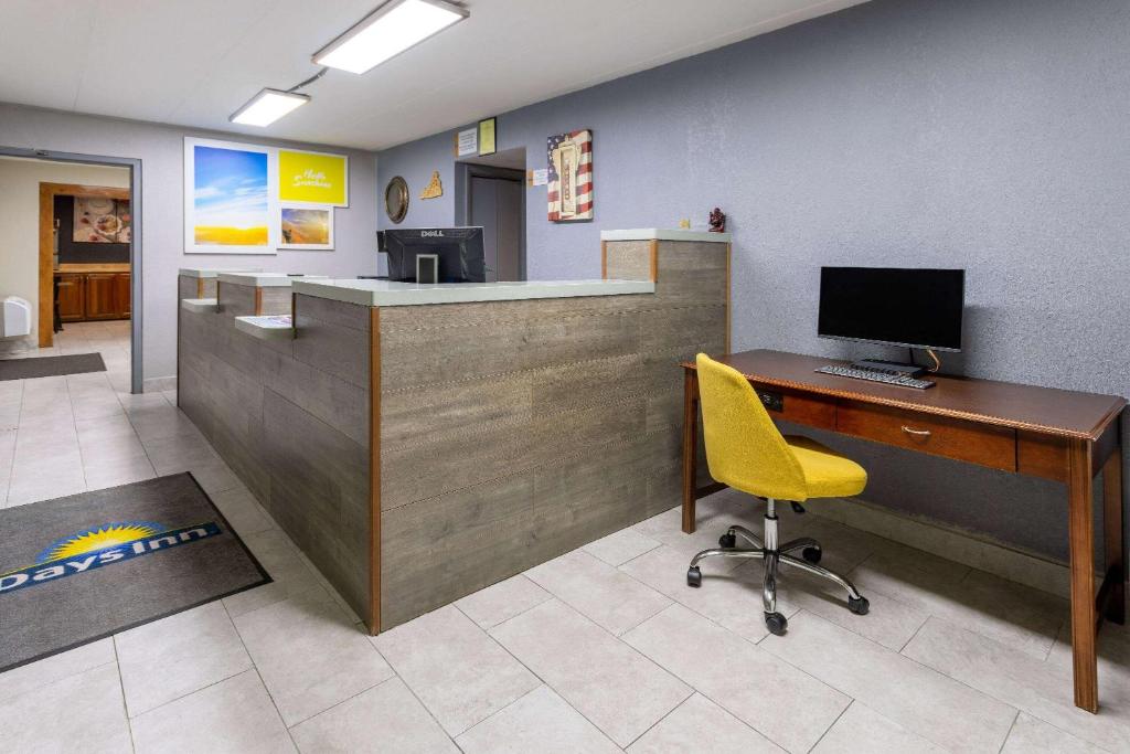 an office with a desk with a computer and a yellow chair at Days Inn by Wyndham Winchester in Winchester