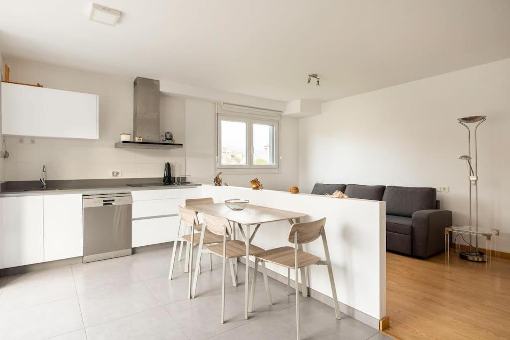 eine Küche und ein Wohnzimmer mit einem Tisch und Stühlen in der Unterkunft Apartamento en Baiona con terraza y parking in Pontevedra