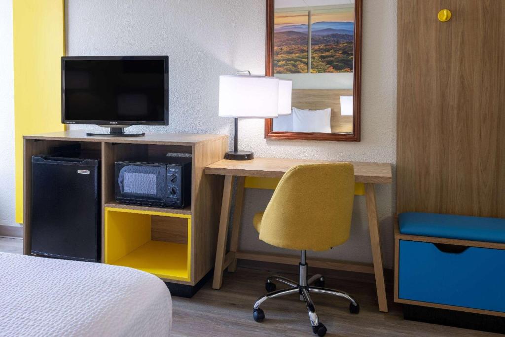 a hotel room with a desk with a television and a chair at Days Inn by Wyndham Winchester in Winchester