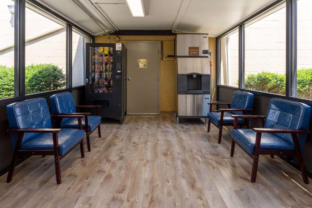 a waiting room with blue chairs and windows at Days Inn by Wyndham Winchester in Winchester