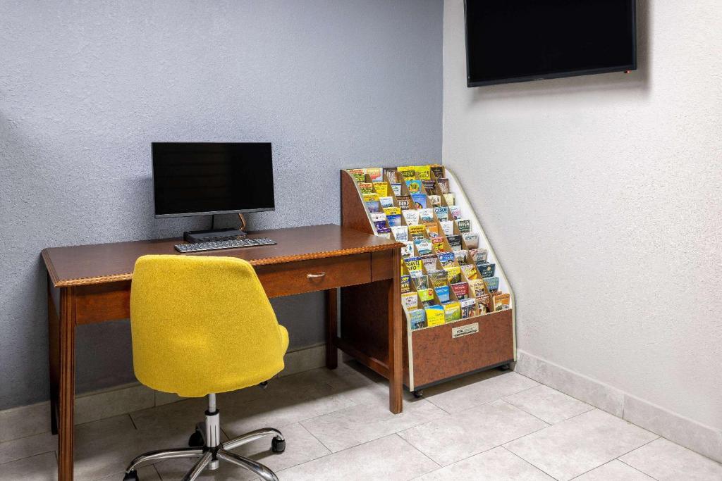 a desk with a computer and a yellow chair at Days Inn by Wyndham Winchester in Winchester