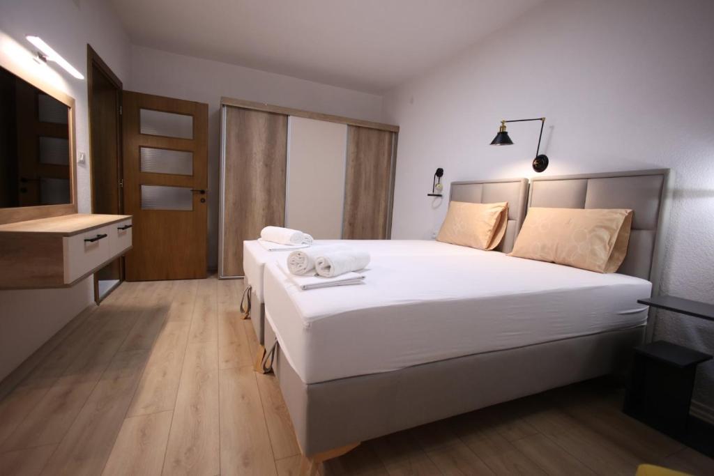 1 Schlafzimmer mit einem großen weißen Bett und einem Badezimmer in der Unterkunft Enjoy Apartments Prilep in Prilep