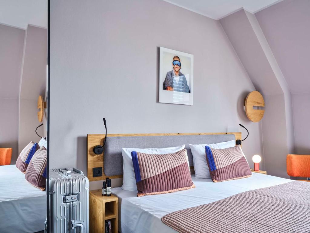 a bedroom with two beds and a picture on the wall at Flemings Hotel Frankfurt-Central in Frankfurt/Main