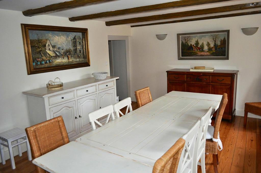 ein Esszimmer mit einem weißen Tisch und Stühlen in der Unterkunft Maison de 3 chambres avec jardin amenage et wifi a Taintrux in Taintrux