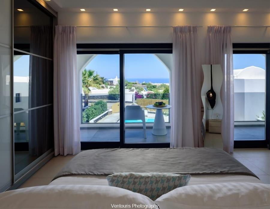 a bedroom with a bed and a large window at Beautiful Santorini Villa 3 Bedrooms Villa Phos Private Pool and Lovely Sea View Exo Gialos in Karterados