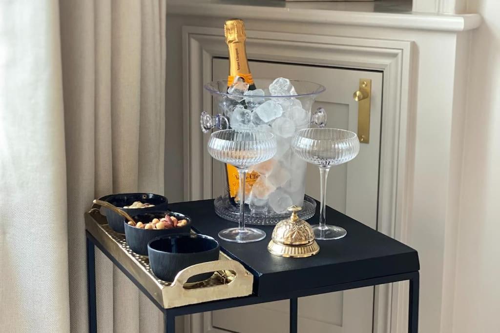 una mesa con copas de vino y una botella de champán en Luxury Georgian Apartment - 5 Minute Walk to Spa en Bath