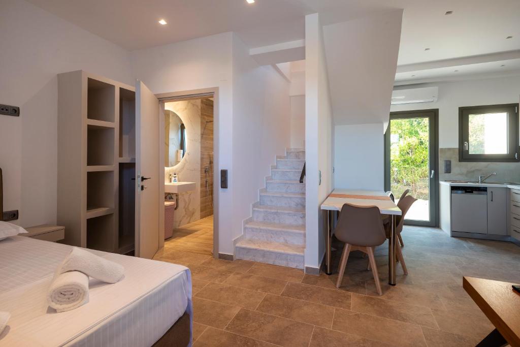 a bedroom with a staircase and a table and chairs at PARGA 4 SEASONS VILLAS in Parga