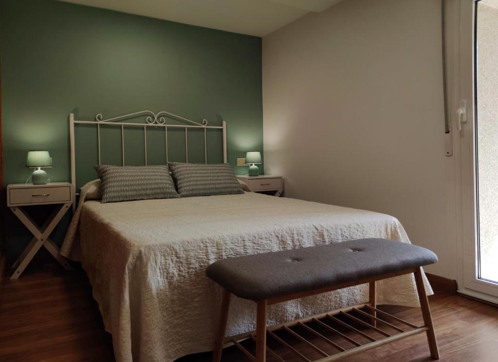 un dormitorio con una cama y una silla junto a ella en Casa d´Amado en Sanxenxo