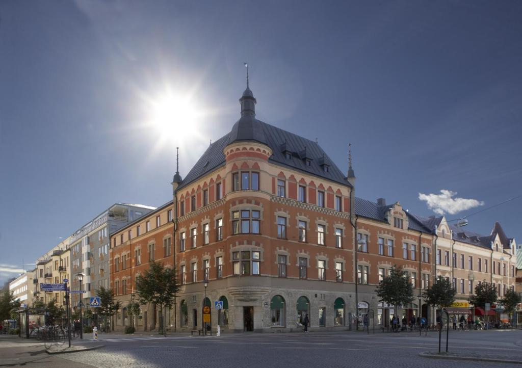 a large red brick building on a city street at Hotell Hjalmar in Örebro