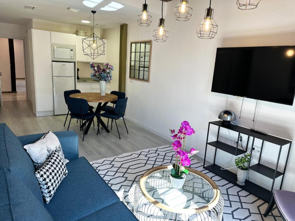 ein Wohnzimmer mit einem blauen Sofa und einem Tisch in der Unterkunft Apartamentos Albaicín Centro Suites 3000 in Granada