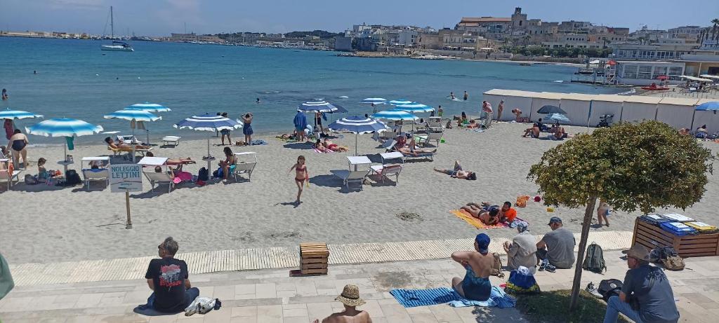 a group of people on a beach with umbrellas at CASA ALTOMARE in Otranto