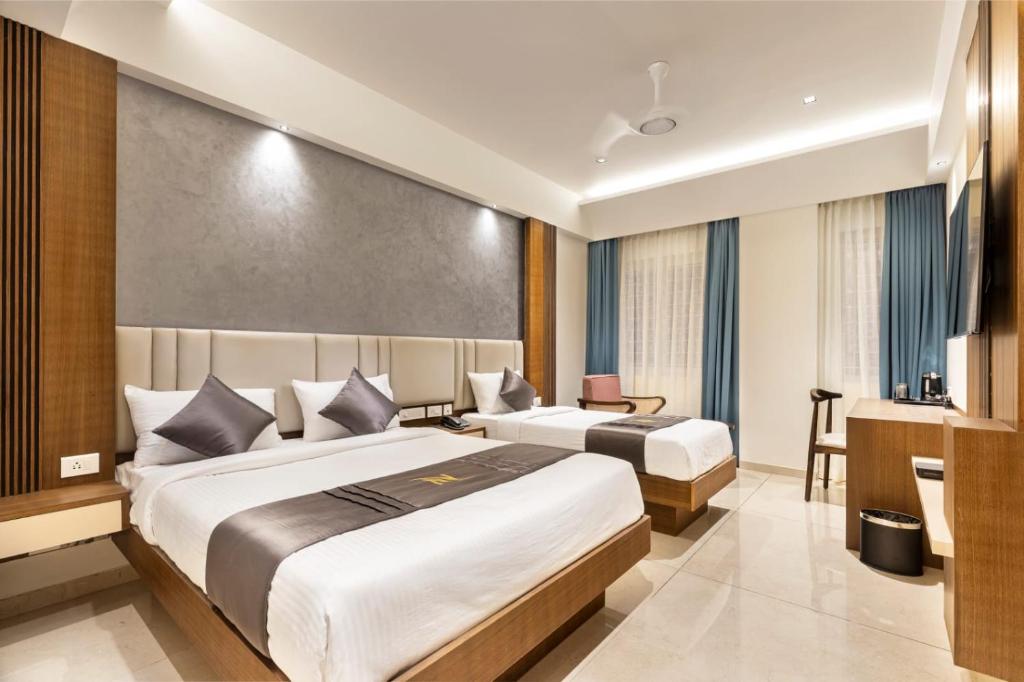 a hotel room with two beds and a desk at Narthaki Boutique Hotel in Bangalore