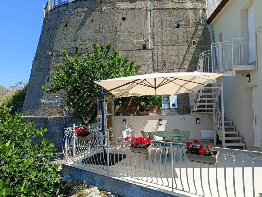 a patio with a table and an umbrella at Stanza Mylai Etna View in Castelmola