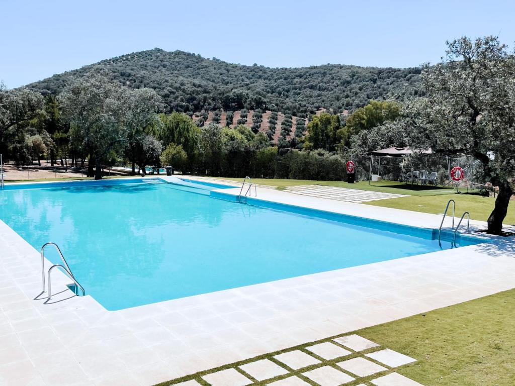 a large swimming pool with a mountain in the background at Bungalows Camping Jimmy Jones in Villaviciosa de Córdoba