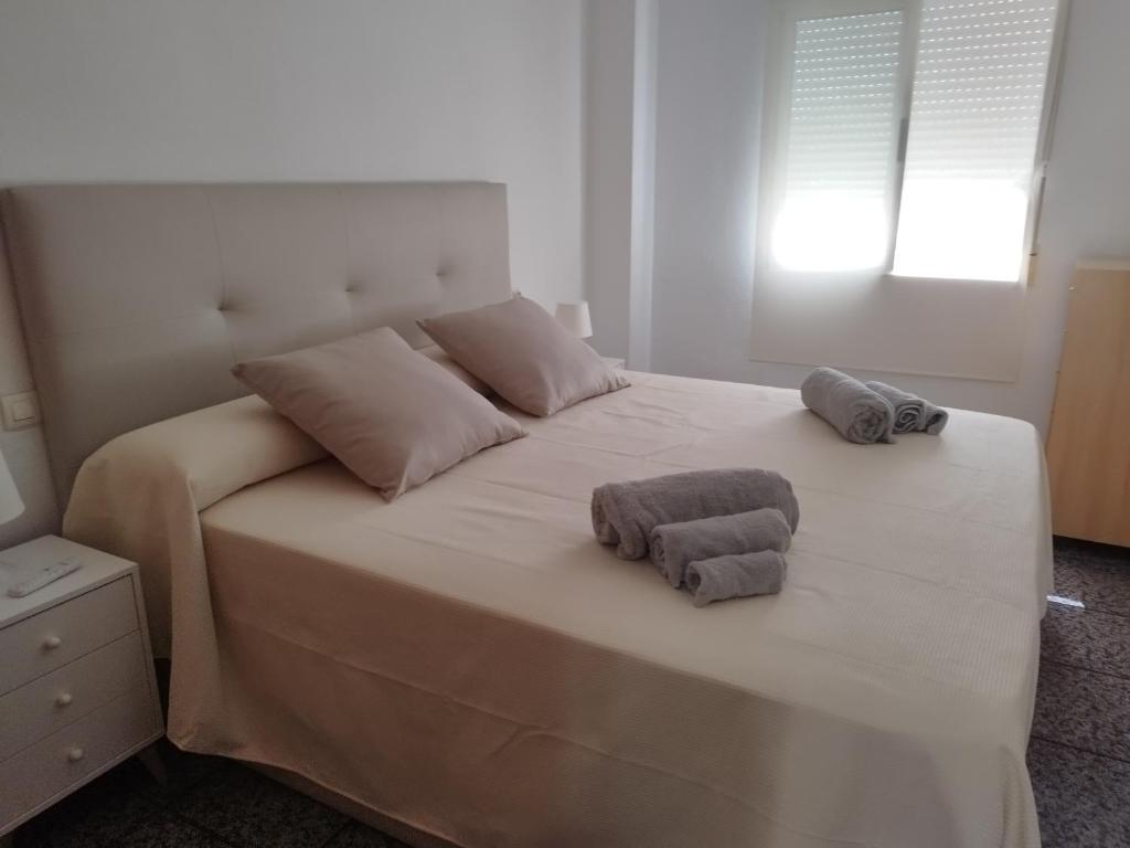 Una cama blanca con dos toallas encima. en Capitanía frente al mar, en Puerto de Mazarrón