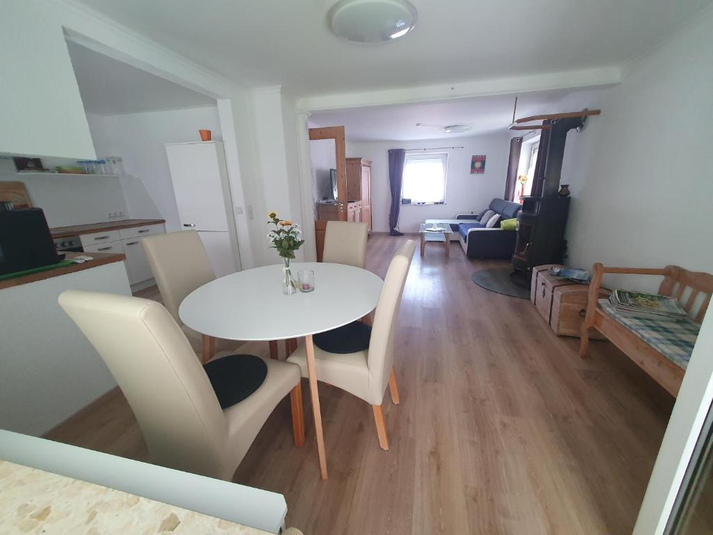 a dining room and living room with a table and chairs at Haus zur Sonne in Lindenberg im Allgäu