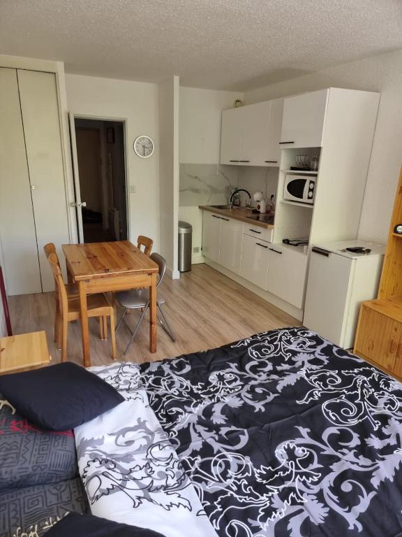 une chambre avec un lit et une cuisine avec une table dans l'établissement Studio La Grande Chaume A, à Enchastrayes