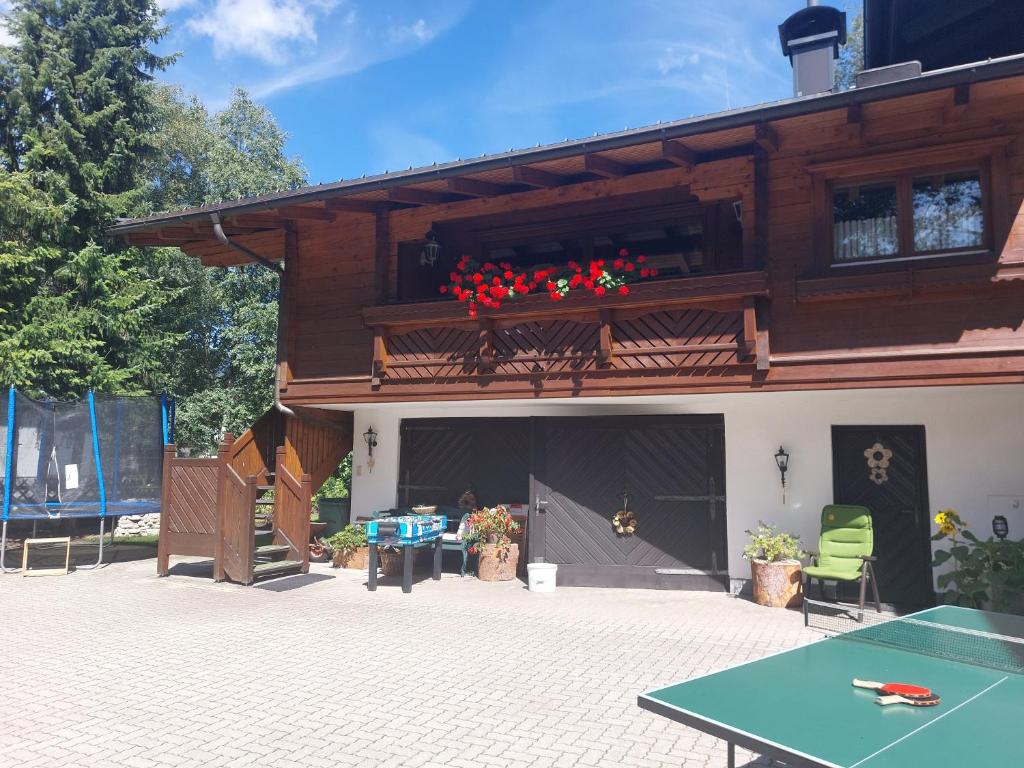 una casa con un balcón con flores rojas. en Appartement Hödlmoser, en Altenmarkt im Pongau