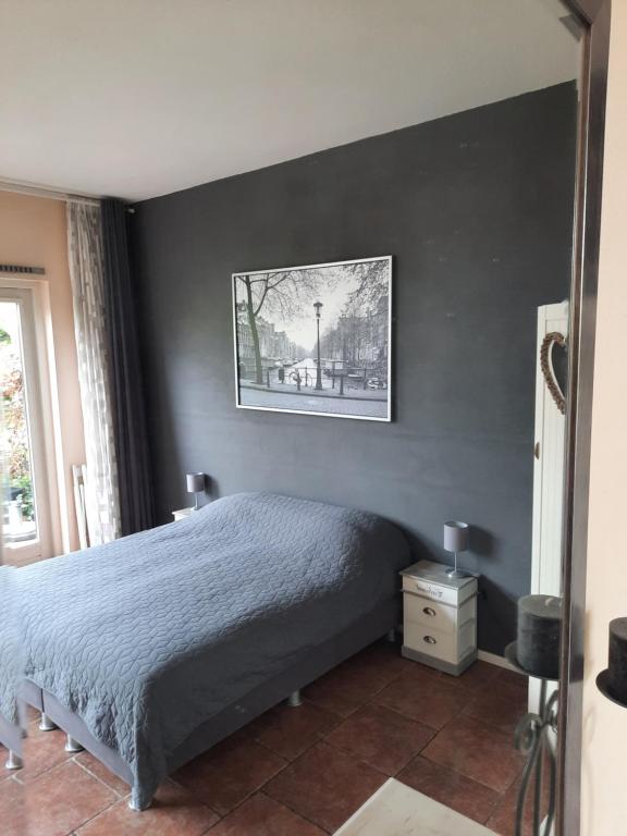 アムステルダムにあるクアレンタ スタジオのベッドルーム1室(ベッド1台付)が備わります。壁に絵が飾られています。