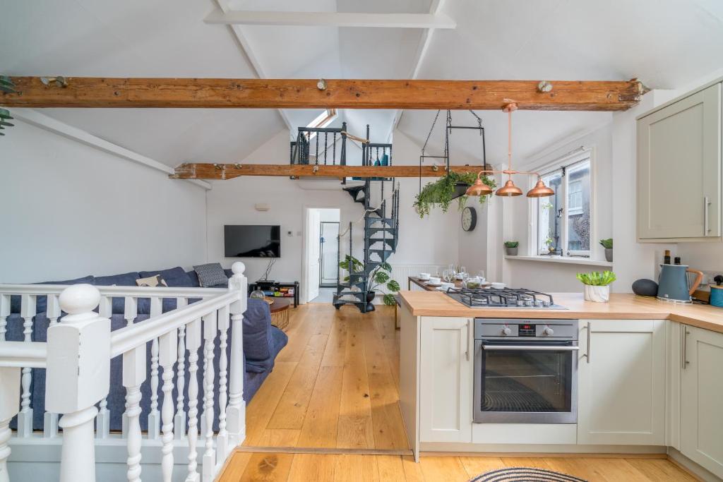 cocina y sala de estar con paredes blancas y suelo de madera. en Stunning 3 Bedroom Duplex with Terrace en Brighton & Hove