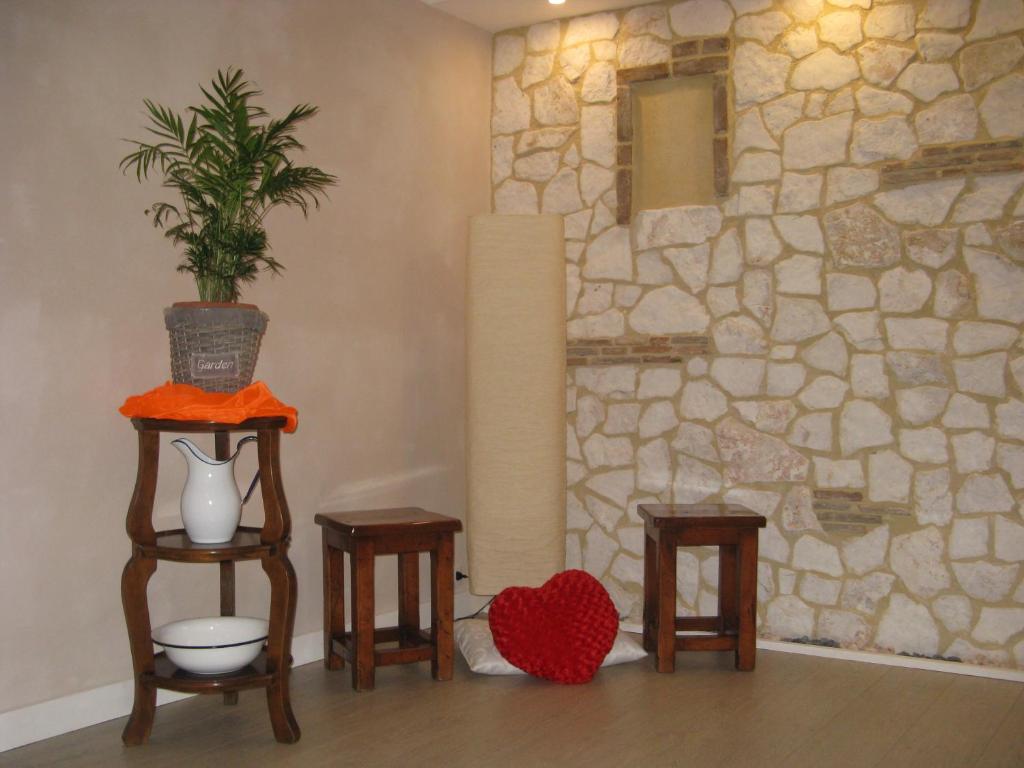 een kamer met 2 tafels en 2 stoelen en een stenen muur bij Wind's House in Pove del Grappa