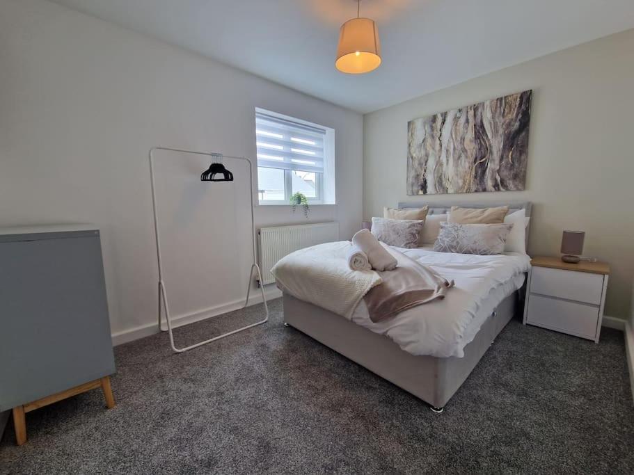 a bedroom with a large bed and a window at Charming 2 BedRoom Tredegar Gem. Sleeps 4 in Tredegar