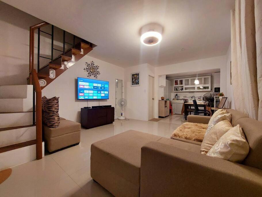 sala de estar amplia con sofá y TV en Cozy Corner at Camella Subic Vista Estates en Subic