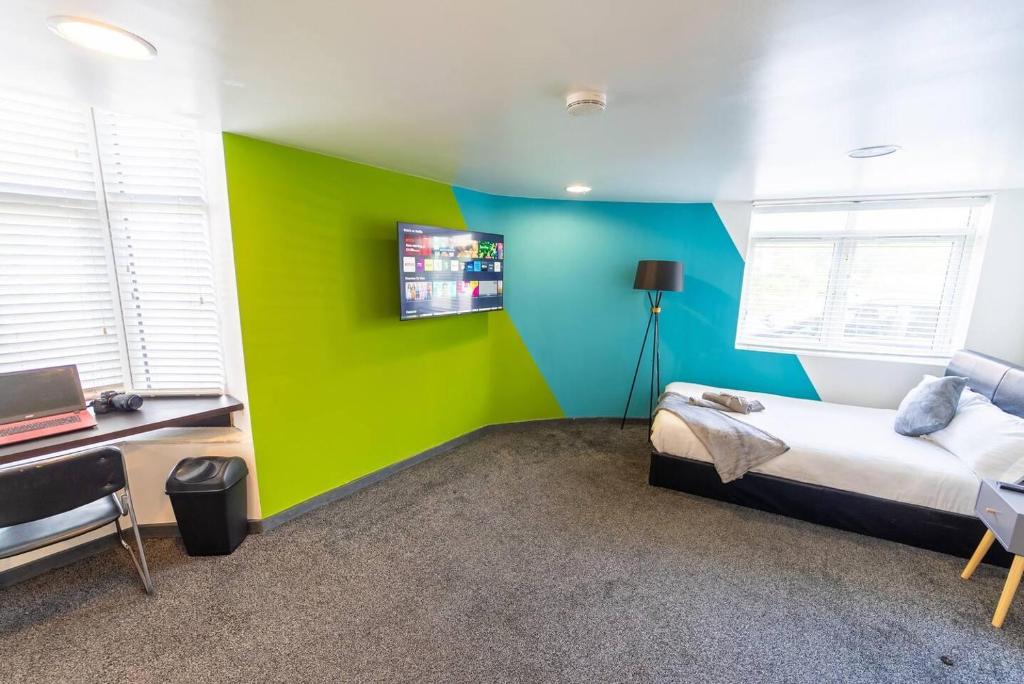 um quarto com paredes verdes e azuis e uma cama em Cosy spacious studio available em Birmingham
