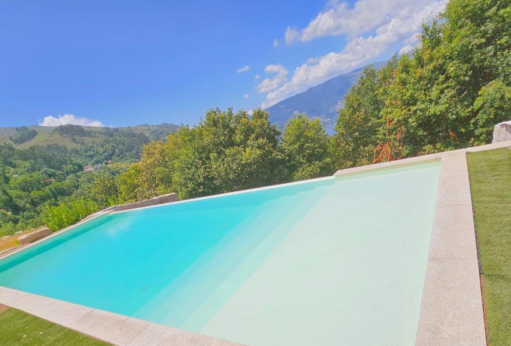 a swimming pool with a view of the mountains at VillaCella - Gerês in Vieira do Minho