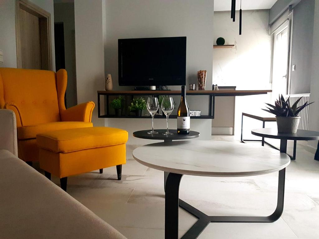 - un salon avec une table, une chaise jaune et une télévision dans l'établissement Cozy Modern Apartment Inside The City Center, à Thessalonique