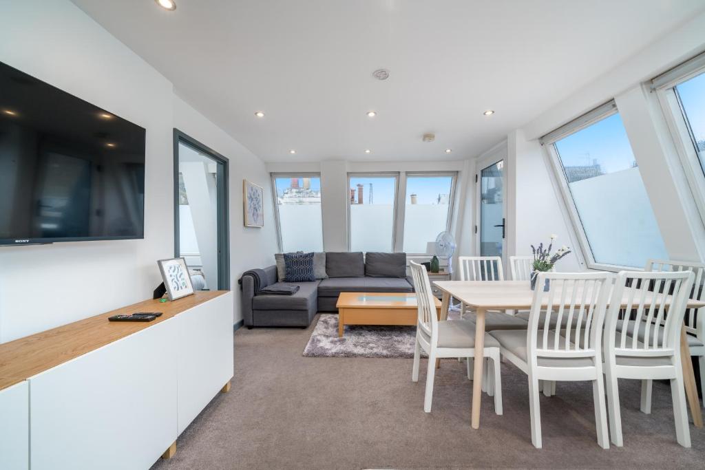 sala de estar con mesa, sillas y sofá en Stunning 2 Bedroom Brighton Apartment - Sleeps 6 en Brighton & Hove