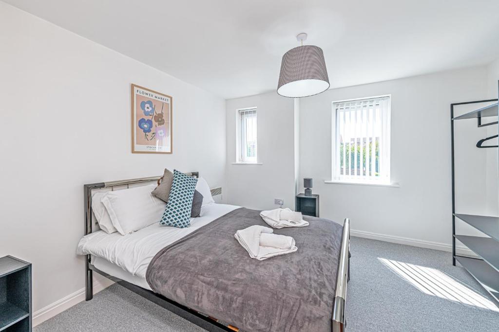 um quarto branco com uma cama com duas toalhas em Two Bedroom 1 mile from Liverpool Airport em Woolton