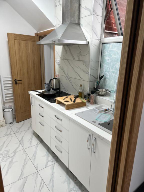 a white kitchen with a stove and a sink at Large room in new flat - Walsall in Bescot