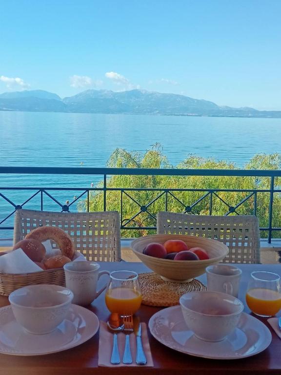 a table with a bowl of fruit and a basket of oranges at Doma Menidi Rooftop Apartment in Menídion