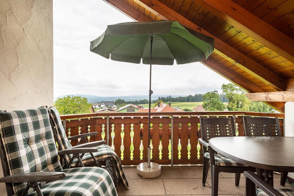 eine Terrasse mit einem Tisch und einem Sonnenschirm auf einer Terrasse in der Unterkunft Drei-mädelhaus Ambs Wohnung 3 