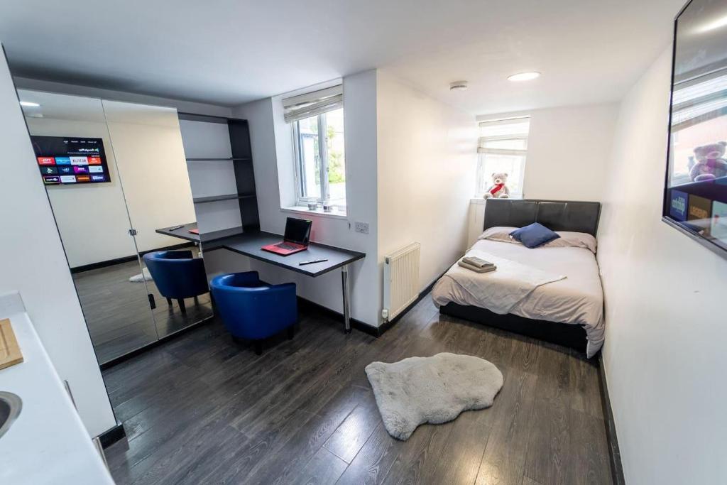 a bedroom with a bed and a desk with a laptop at Studio close to Selly Oak train station in Birmingham