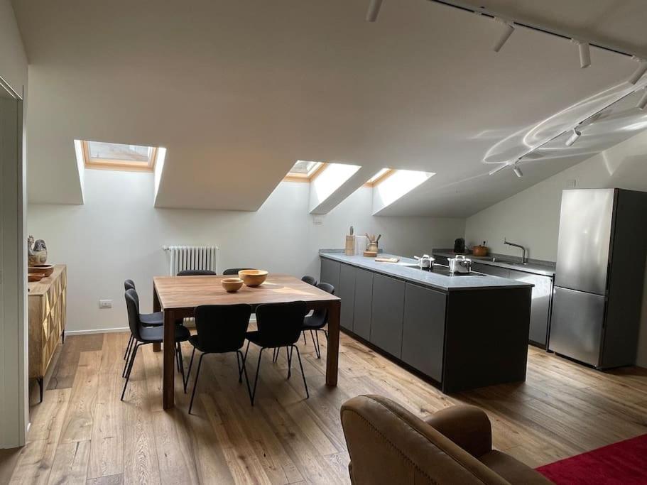 a kitchen with a table and chairs in a room at Mansarda Malenca in Chiesa in Valmalenco