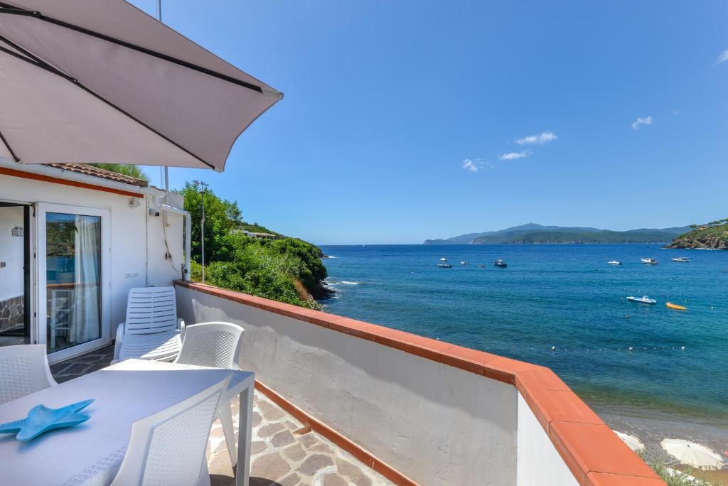 a balcony with a table and chairs and the ocean at Villa Oda - Trilocale sul mare in Capoliveri