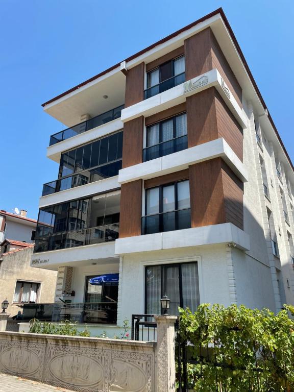 wysoki budynek z płotem przed nim w obiekcie Deniz apartment w mieście Yalova