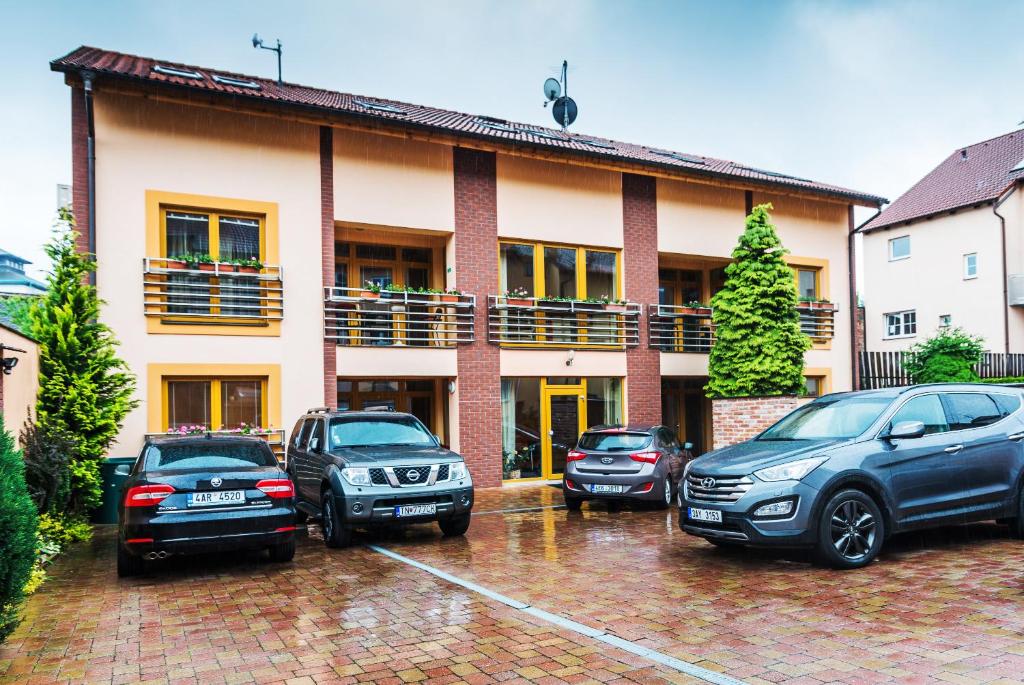 eine Gruppe von Autos, die vor einem Gebäude geparkt sind in der Unterkunft Hotel City in Pardubice