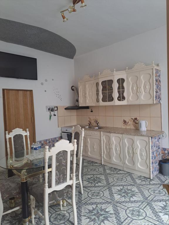 a kitchen with white cabinets and a table with chairs at Apartmá u Faltýnka in Brněnské Ivanovice