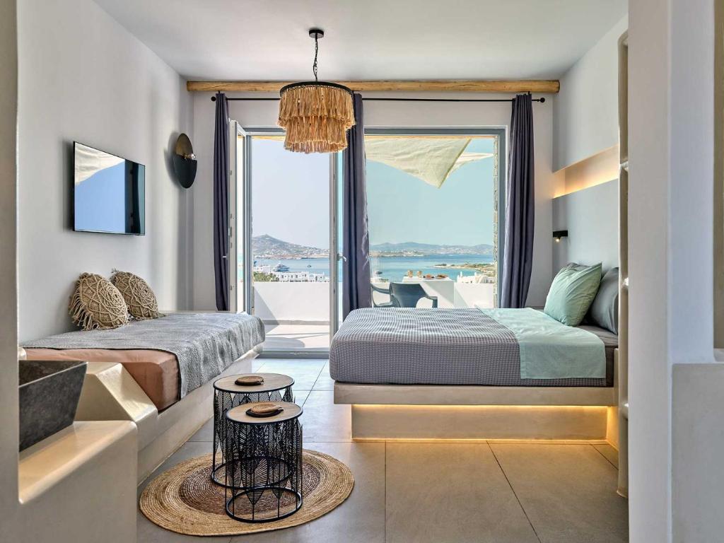 a bedroom with two beds and a large window at Ocean View Paros in Parikia