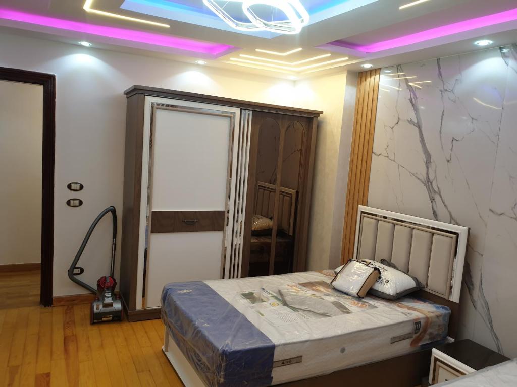 Zimmer mit einem Bett in einem Zimmer mit lila Lichtern in der Unterkunft اللبيني فيصل شارع جمال الدين البنا فوق عمارة الرحمة فوق صيانة زانوسي الجيزة in Kairo