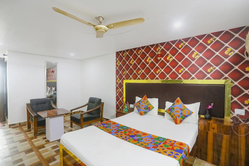 a bedroom with two beds and a table and chairs at FabExpress Umbrella in Patna