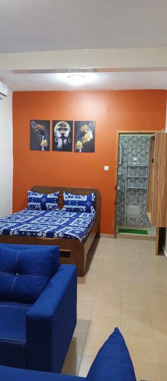 達喀爾的住宿－RÉSIDENCE NGUARY，一间卧室配有一张床和一张沙发