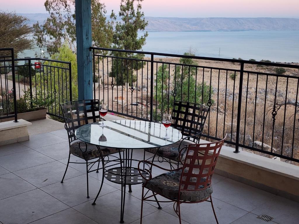 einen Tisch und Stühle auf einem Balkon mit Aussicht in der Unterkunft מול הכנרת Over looking the Sea of Galilee in Chorazim