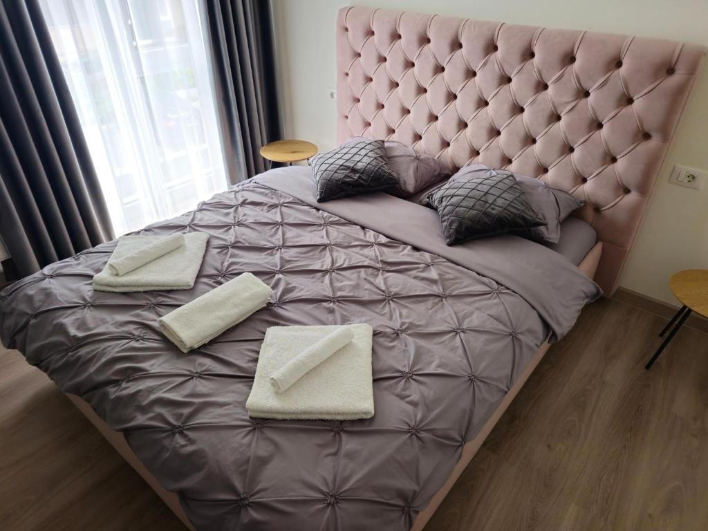 a bedroom with a large bed with a large headboard at Plaza Residence in Braşov