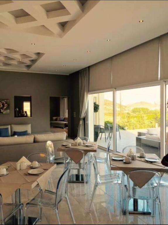 a living room with tables and chairs and a couch at Ammos Suites in Platy