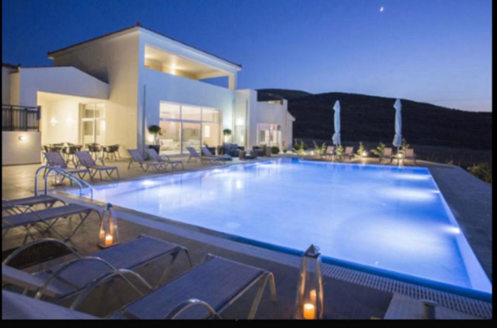 a large swimming pool in front of a house at Ammos Suites in Platy